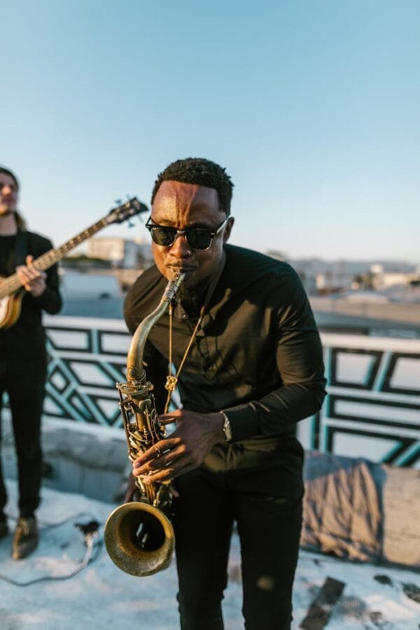 Talented musician performing on saxophone outdoors during sunset, capturing vibrant musical energy.